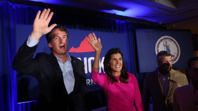 Republican gubernatorial candidate Glenn Youngkin, left, waves to supporters while campaigning with former South Carolina Gov. Nikki Haley in McLean, Virginia, on July 14. Youngkin is running against former Virginia Gov. Terry McAuliffe. (Win McNamee/Getty Images)