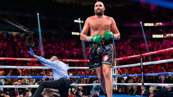 WBC heavyweight champion Tyson Fury (center) floors Deontay Wilder for the third and final time on Saturday as referee Russell Mora signals his 11th-round knockout in Saturday's bout in Las Vegas. (Ryan Hafey/Premier Boxing Champions) 
