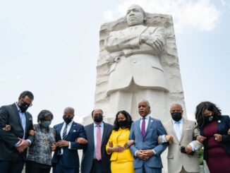 Martin Luther King III, his wife Arndrea Waters King, and Rev. Al Sharpton, stand with locked arms praying with Texas Legislative Black Caucus members, from left to right: Sheryl Cole, Jarvis Johnson, Rhetta Andrews Bowers, Ron Reynolds, Carl O. Sherman, Jasmine Crockett, and Shawn Thierry, at the Martin Luther King, Jr. Memorial in Washington, D.C. on July 28. (Cheriss May/Getty Images)