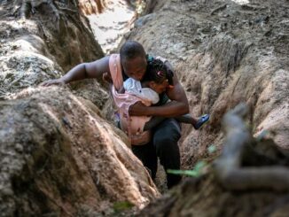 A Haitian father carries his daughter in the Darien Gap, between Colombia and Panama, on Oct. 5. It is the most dangerous passage for migrants walking through the Americas. They often hope to reach the United States, while others stay in Mexico. (John Moore/Getty Images)