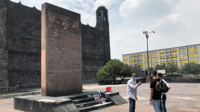 A memorial was built at the site of the tragedy. In front of it, a man narrates the events of Oct. 2, 1968, to a couple of visitors. (Julio Guzmán/Zenger)